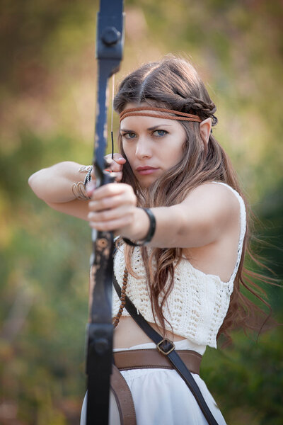 Elf mythical hunter girl shooting bow and arrow