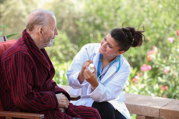 Dr of verpleegkundige medicatie geven hogere patiënt. — Stockfoto