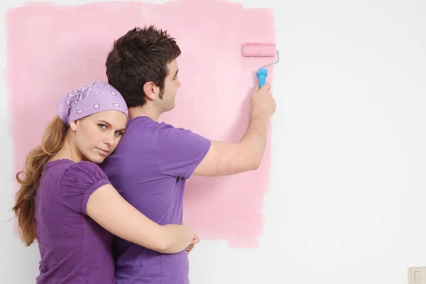 Young couple painting baby nursery in new home — Stock Photo, Image