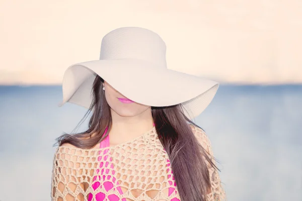 Módní beach žena s klobouku proti slunci seběhla zahrnující jedno oko. — Stock fotografie