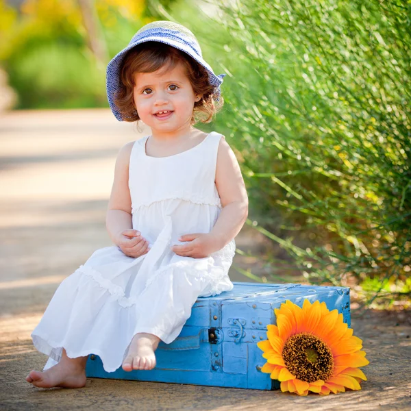 Glückliches Kind, das im Sommer draußen sitzt — Stockfoto