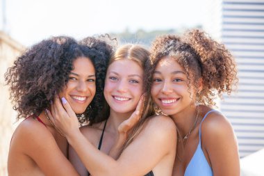 Kumsalda tatilde olan farklı ırklardan mutlu arkadaşlar.