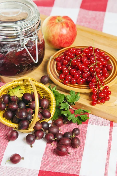 Джем з ягодами червоної смородини і агрусу на столі — стокове фото
