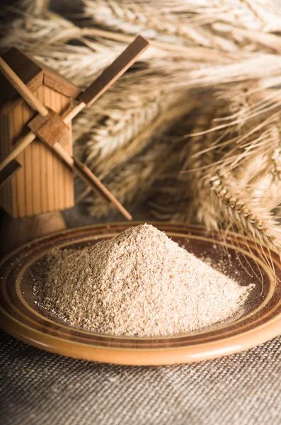 Wholemeal flour and wheat on cloth sack, close-up — Stock Photo, Image