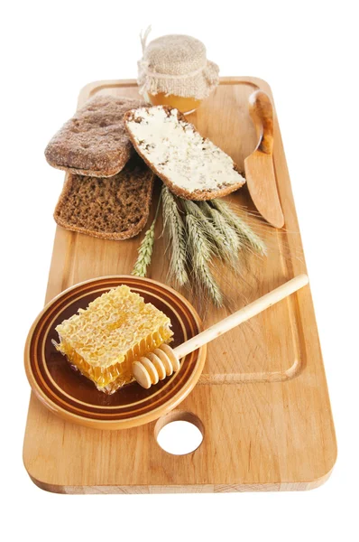 Miel, espiga y pan en la mesa — Foto de Stock