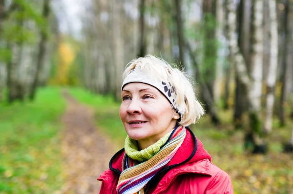 Kobieta w średnim wieku w parku jesień — Zdjęcie stockowe