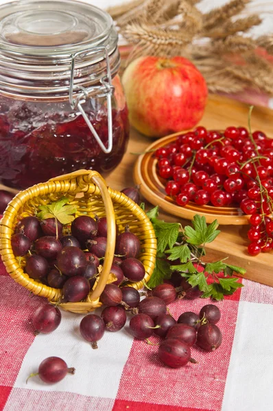 Mermelada con bayas de grosella roja y grosella en la mesa — Foto de Stock