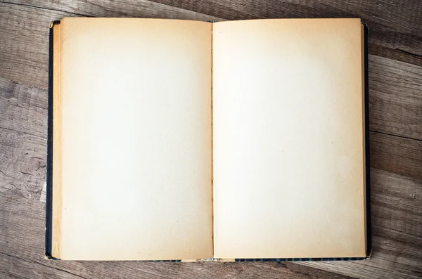 Vieux livre ouvert sur une surface en bois — Photo