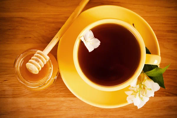 A visão superior em uma xícara de chá com uma flor de um jasmim e mel — Fotografia de Stock