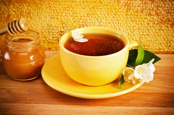 Cup of tea with a flower of a jasmin and honey — Stock Photo, Image