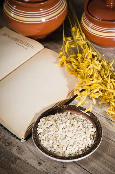 Natura morta con farina d'avena e un libro aperto — Foto Stock