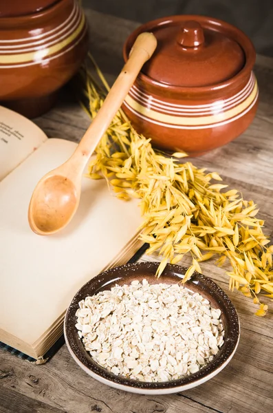 Natura morta con farina d'avena e un libro aperto — Foto Stock