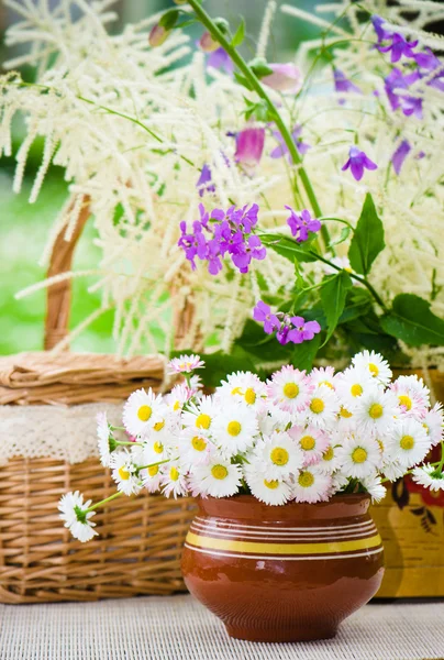 Ramo de flores silvestres en una olla a la mesa — Foto de Stock