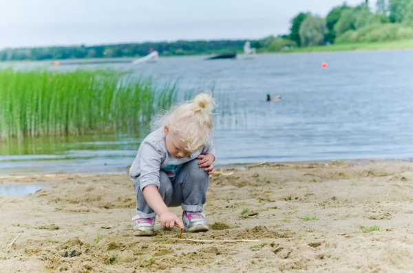 Fiú és lány játszik a homok, a tó partján — Stock Fotó