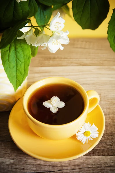 Cup of tea and a bouquet of blooming Jasmine — Stock Photo, Image