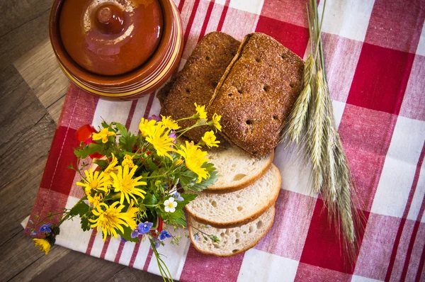 Stilleben med bröd, blommor och potten — Stockfoto