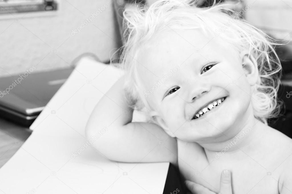 Black and white portrait of a young smiling child