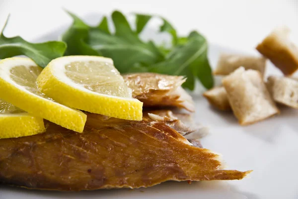 Smoked fish with lemon and salad — Stock Photo, Image