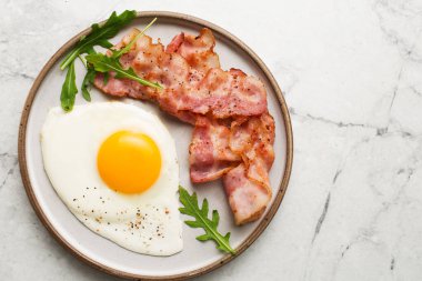 İngiliz kahvaltısı. Yumurta ve kızarmış pastırma. Mermer bir masada kahvaltı servisi. Yağda yumurta..