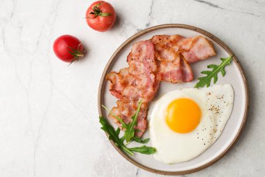 İngiliz kahvaltısı. Yumurta ve kızarmış pastırma. Domatesli bir fincan. Mermer bir masada kahvaltı servisi. Yağda yumurta..