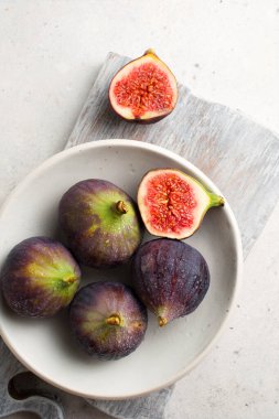 Hafif arka planda incirler. Taze meyve hasadı. Organik yiyecekler. Tahtada incir kes. Yemek fotoğraflarında metin için yer