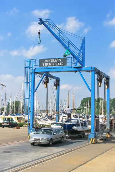 Crane unloading a boat with a trailer on the pier Huizen. Nether — Stock Photo, Image