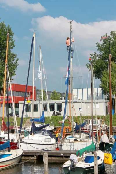The man at the mast sailing yacht in the port of Huizen. Netherl — Stock Photo, Image