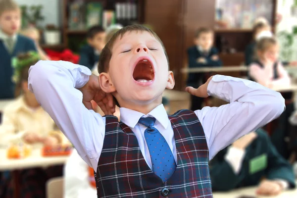 Kind gähnt bei der Lektion — Stockfoto