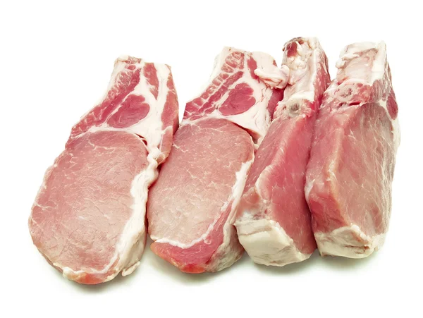 Algumas costeletas de porco em um fundo branco — Fotografia de Stock