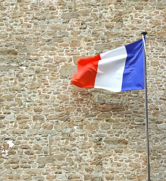 French flag near a stone fortress wall — Stock Photo, Image
