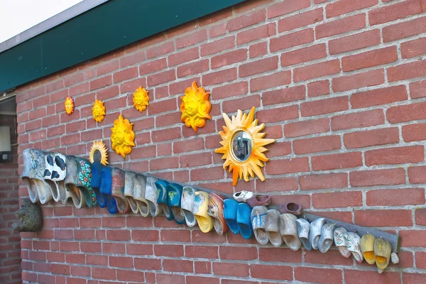 Wall dutch house decorated old shoes and sun. Netherlands — Stock Photo, Image