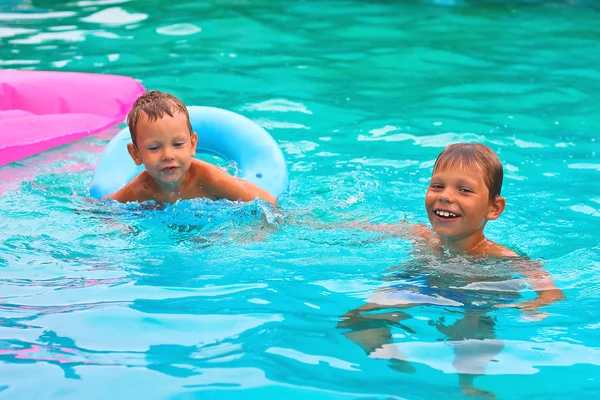 Two brothers are swimming in the pool — Stock Photo, Image