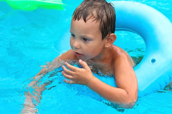 Preschool boy swims in pool on summer vacations — Stock Photo, Image