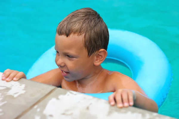 Preschool boy swims in pool on summer vacations — Stock Photo, Image