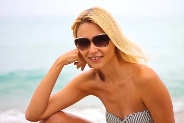 Young beautiful woman on the beach near the sea — Stock Photo, Image