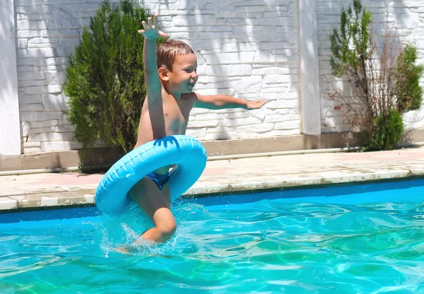 Preschool boy are jumping to the swimming pool — Stock Photo, Image