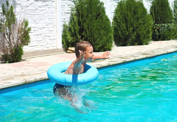 Børnehaveklassen dreng springer til swimmingpoolen - Stock-foto