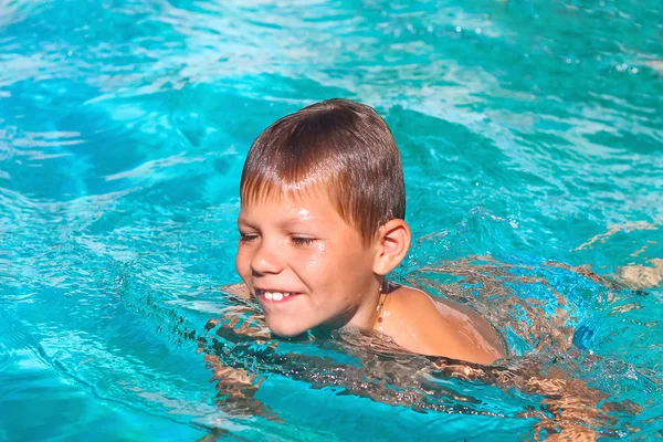 Lachende jongen in het zwembad op de zomervakanties — Stockfoto