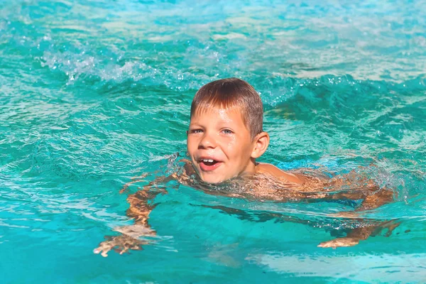 Garoto sorridente na piscina em férias de verão — Fotografia de Stock