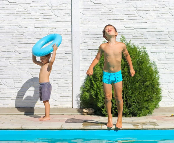 İki kardeş bir yüzme havuzu yaz tatili oteller. — Stok fotoğraf
