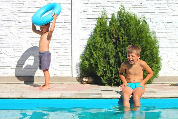 Two brothers near a swimming pool at summer vacation — Stock Photo, Image