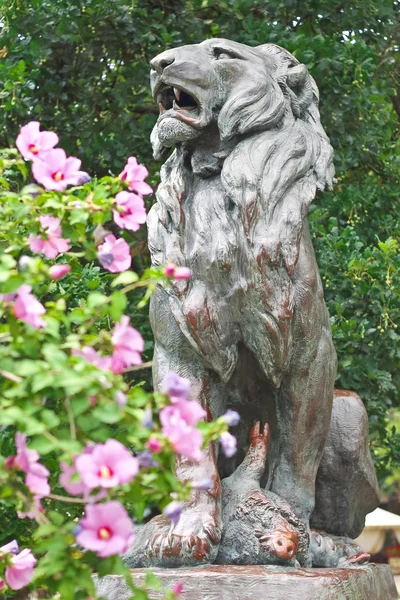 Socha lovili lva v městském parku — Stock fotografie