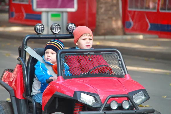 Due fratelli guidano la macchina rossa. — Foto Stock