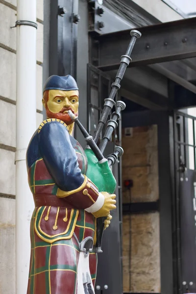 Estátua de Bagpiper perto da entrada do edifício . — Fotografia de Stock