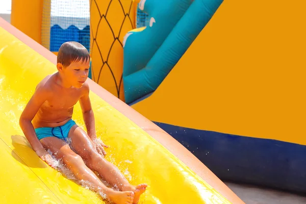 Niño entusiasta en el tobogán en el parque acuático — Foto de Stock