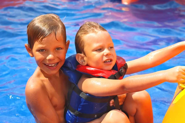 Dos hermanos en piscina en el parque acuático —  Fotos de Stock