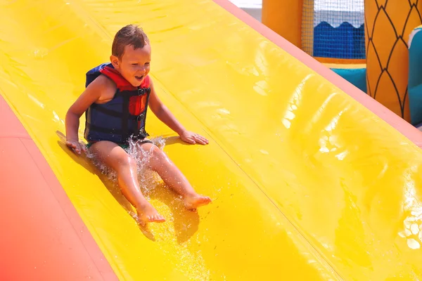 Enthusiastic kid on slide in the waterpark — Stock Photo, Image