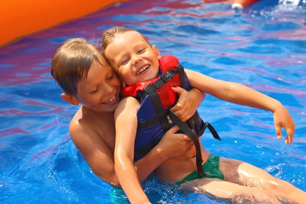 Dois irmãos na piscina do parque aquático — Fotografia de Stock
