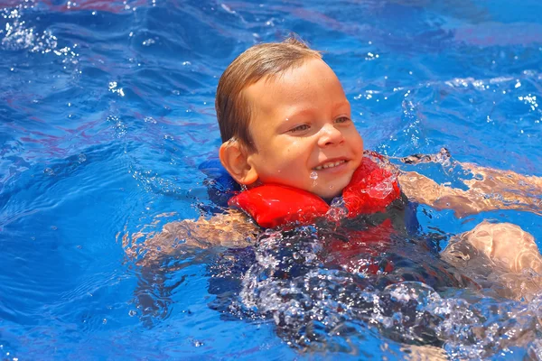 Enfant enthousiaste en gilet au parc aquatique de la piscine — Photo