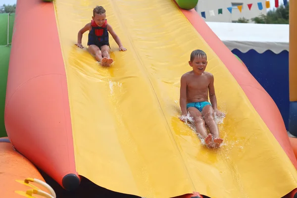 Enthusiastic kids on slide in the water park — Stock Photo, Image